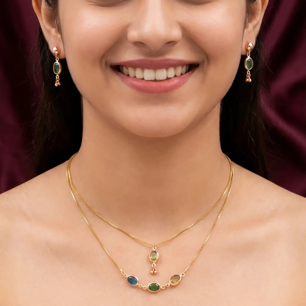 Close-up of a woman wearing a gold necklace with gemstones and matching earrings.