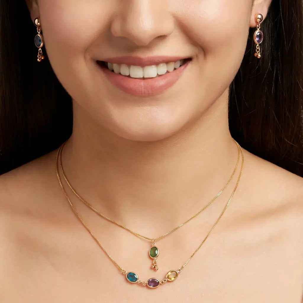 Close-up of a woman wearing a gold necklace with gemstones and matching earrings.