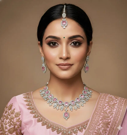 Woman wearing traditional jewelry with a pink outfit against a brown background