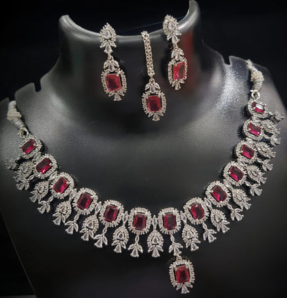 Jewelry set with necklace and earrings featuring red gemstones on a black background