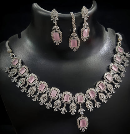 Necklace and earrings set with pink stones on a black background